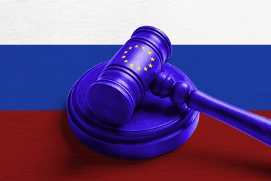 Economic sanctions against Russia because of invasion in Ukraine. Judge's gavel in color of European flag on background in color of Russian flag