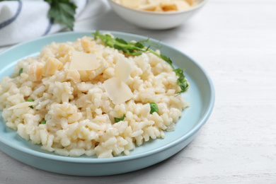 Photo of Delicious risotto with cheese on white wooden table, closeup
