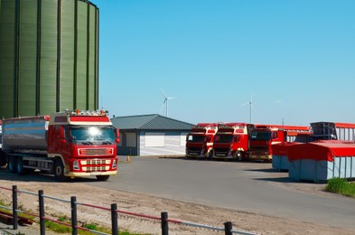 Photo of Modern granary for storing cereal grains and parked trucks outdoors