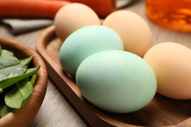 Photo of Naturally painted Easter eggs on wooden table, closeup. Spinach used for coloring