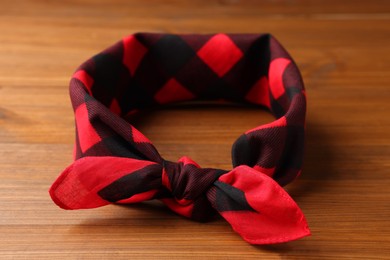 Tied red checkered bandana on wooden table