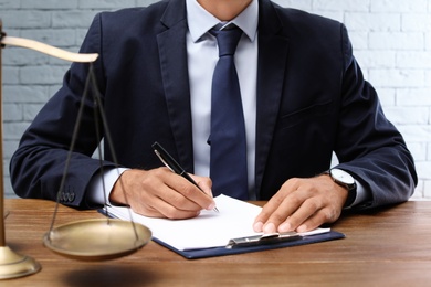 Male lawyer working with documents at table in office