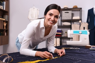 Dressmaker marking fabric with chalk in workshop