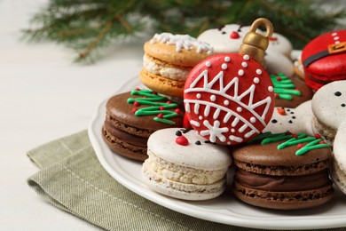 Photo of Beautifully decorated Christmas macarons on white wooden table, closeup. Space for text