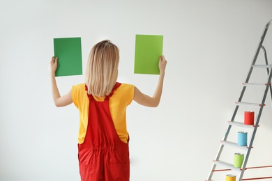 Photo of Young woman choosing color for wall on white background