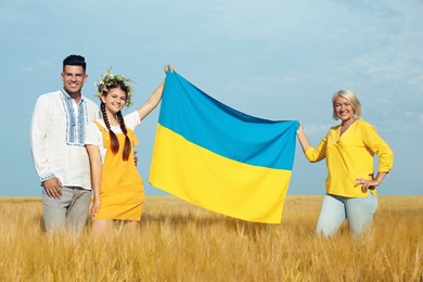 Happy family with national flag of Ukraine in field
