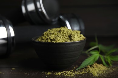 Photo of Hemp protein powder and fresh leaves on wooden table, closeup