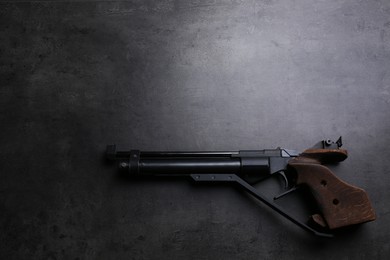 Sport pistol on black table, top view with space for text. Professional gun