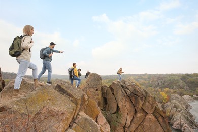 Group of hikers with backpacks at top of mountain