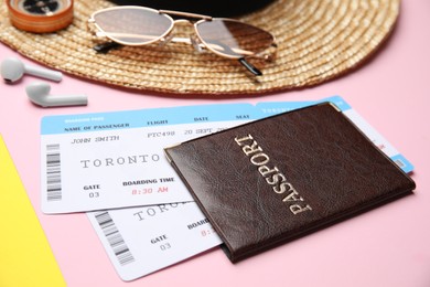 Passport with tickets near travel items on color background, closeup