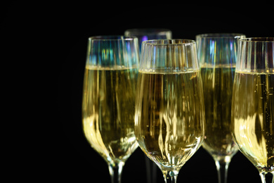 Glasses of champagne on black background, closeup