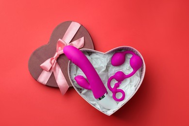 Gift box with sex toys on red background, top view. Space for text