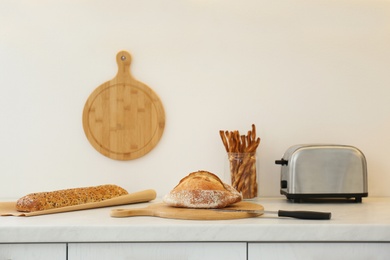 Photo of Loaves of bread and grissini on counter in kitchen