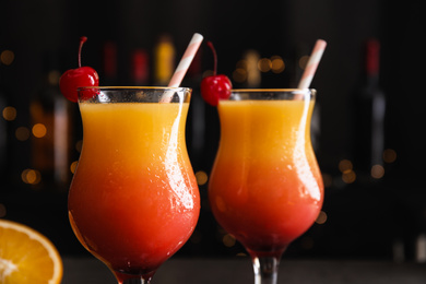 Fresh alcoholic Tequila Sunrise cocktails against blurred lights, closeup
