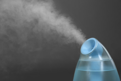 Modern air humidifier on grey background, closeup. Space for text