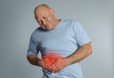 Image of Mature man suffering from liver pain on light grey background