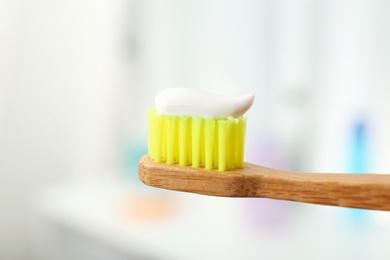 Brush with toothpaste on blurred background, closeup