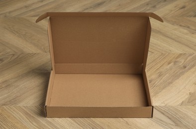 One empty open cardboard box on floor