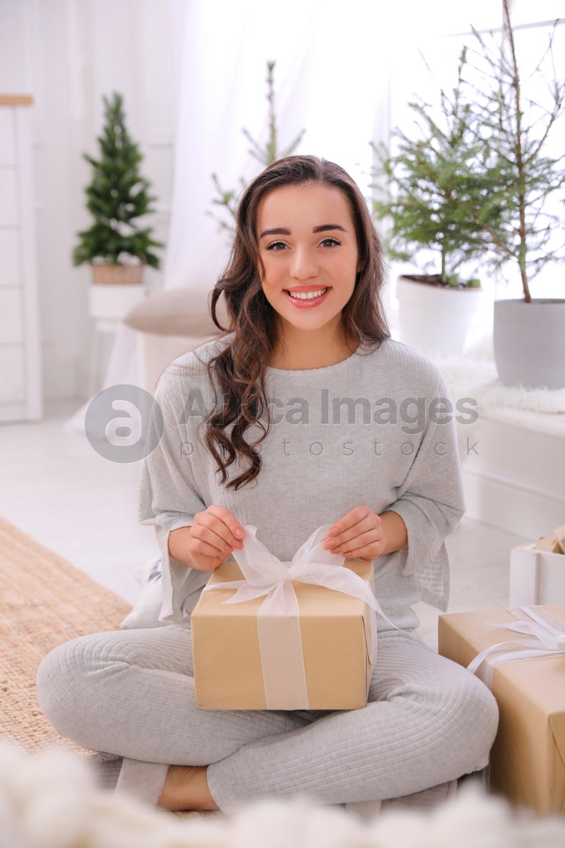 Woman with gift box on floor at home