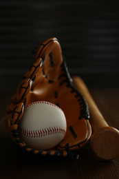 Leather baseball ball, bat and glove on wooden table