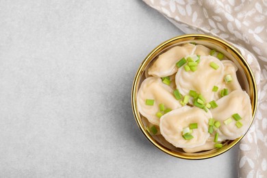 Photo of Cooked dumplings (varenyky) with tasty filling and green onion on light table, top view. Space for text