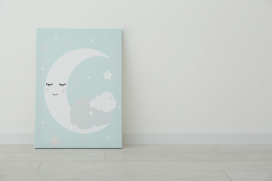 Adorable picture of moon on floor near white wall, space for text. Children's room interior element