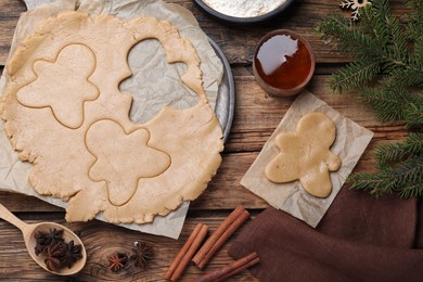 Photo of Flat lay composition with homemade gingerbread man cookies on wooden table