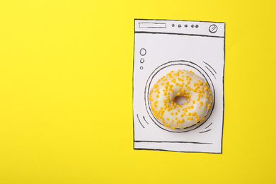 Washing machine made with donut and paper on yellow background, top view. Space for text