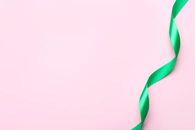 Beautiful ribbon on pink background, top view. Space for text