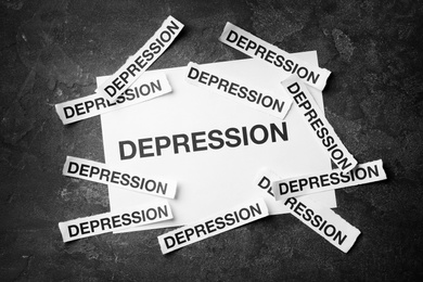 Many papers with words Depression on dark background, top view