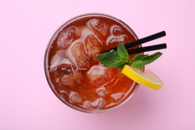 Delicious iced tea with lemon and mint on pink background, top view
