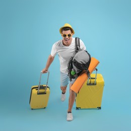 Male tourist with travel backpack and suitcases running on turquoise background