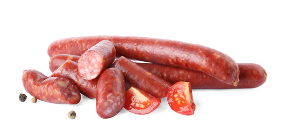 Delicious smoked sausages with tomato and pepper on white background
