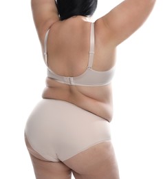 Back view of overweight woman in beige underwear on white background, closeup. Plus-size model