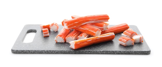 Black board with delicious crab sticks isolated on white