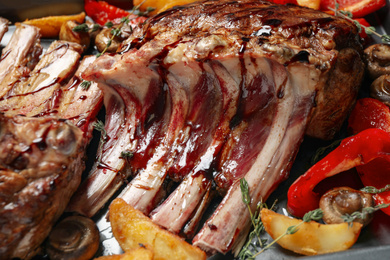 Photo of Delicious roasted ribs with garnish, closeup view