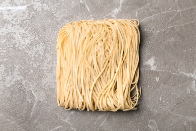 Photo of Block of quick cooking noodles on color background, top view