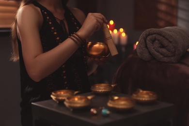 Healer using singing bowl in dark room, closeup