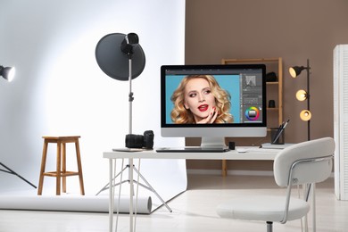 Retoucher's workplace. Computer with photo editor application, camera and graphic tablet on table in studio