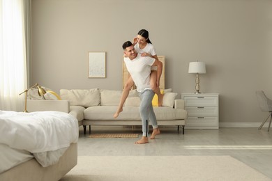 Photo of Happy couple in pyjamas having fun at home