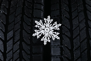 Winter tires with decorative snowflake as background, closeup