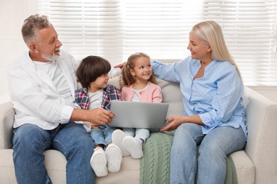 Photo of Happy grandparents spending time with grandchildren at home