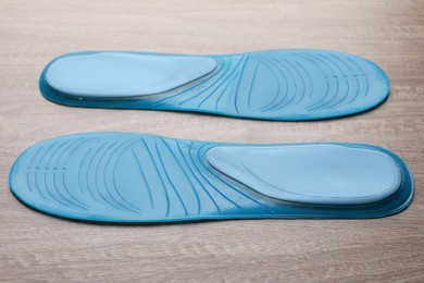 LIght blue orthopedic insoles on wooden background