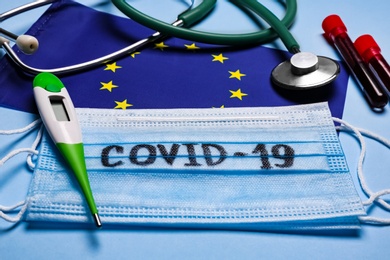 European Union flag, protective masks and medical items on light blue background. Coronavirus outbreak