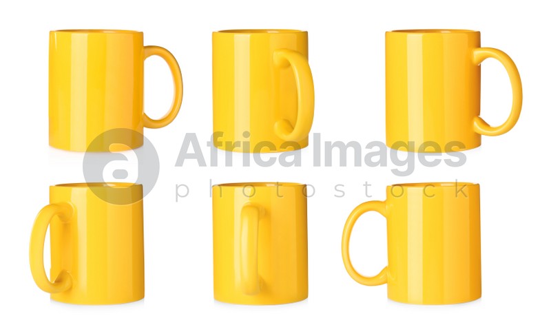 Set with yellow ceramic mugs on white background