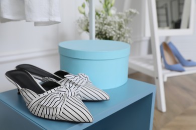 Elegant women's shoes on light blue shelf in dressing room
