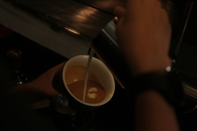 Photo of Barista making delicious aromatic coffee in cafe, closeup