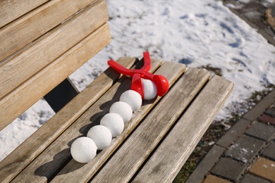Snowballs and plastic tool on bench outdoors