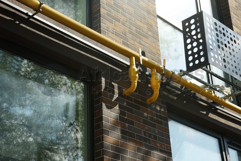 Photo of Yellow gas pipe near building in residential area outdoors