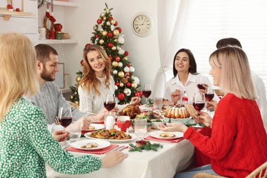 Happy family with their friends enjoying festive dinner at home. Christmas Eve celebration